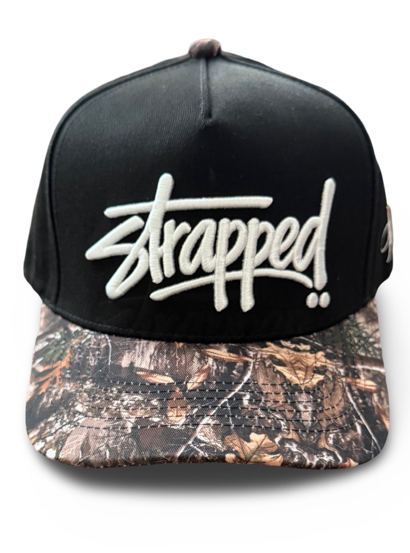 “Strapped” script camo brim snapback